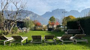 a group of chairs and a table in the grass at Le Chalet de la Plage in Sévrier