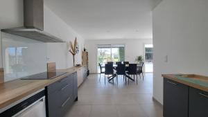 a kitchen with a counter and a dining room at Maison tout confort proche Azay-le-Rideau 8 p in Azay-le-Rideau