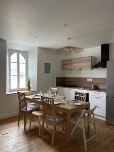a dining room with a table and chairs and a kitchen at Appartement 2 etoiles haut de gamme Le Pompidou in Les Sables-dʼOlonne +21 photos
