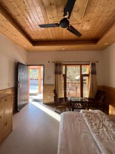a bedroom with a bed and a ceiling fan at Brahma Cottages in Kasol