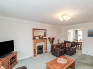 ein Wohnzimmer mit einem TV und einem Kamin in der Unterkunft Bray Nook, 7 Craikewells in Bridlington