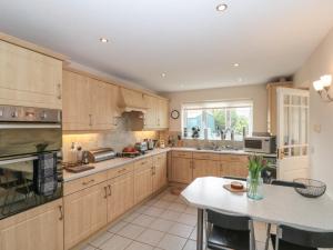 eine große Küche mit Holzschränken und einem Tisch in der Unterkunft Bray Nook, 7 Craikewells in Bridlington