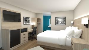 a bedroom with a bed and a desk with a tv at Best Western Greenville Airport in Greenville