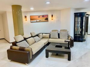 a living room with a couch and a coffee table at Cozycasa By Nattis group 4 BR - Jacuzzi & private garden in Kondapur
