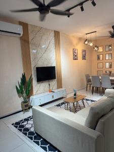 a living room with a couch and a tv at MelDy Guesthouse Alor Gajah in Kampong Jelatang