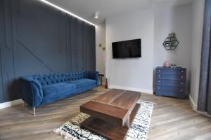 a living room with a blue couch and a table at Central, Contractor&family Friendly, Smarttv in Sunderland