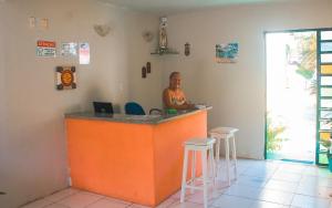 a woman sitting at a bar in a room at Pousada e Restaurante Sombra dos Coqueiros in Trairi +121 photos