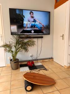 a flat screen tv hanging on a wall with a skateboard at Villa Valhalla - 400m from beach, sauna and big heated pool in Labenne