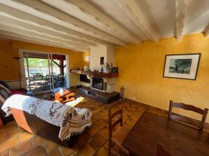 a living room with yellow walls and a fireplace at Villa Valhalla - 400m from beach, sauna and big heated pool in Labenne +28 photos