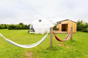 a couple of hammocks in a field with a tent at Deere Dome in Othery
