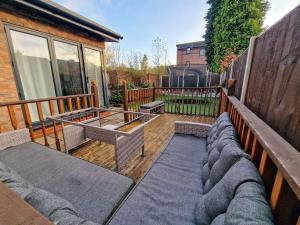 a patio with a table and benches and a fence at 4 Bed Home in Altrincham by City SuperHost in Timperley