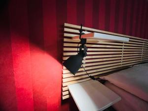 a lamp on a red wall next to a bench at Nova21 in Naples
