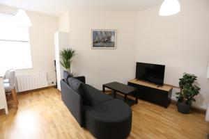 a living room with a black couch and a tv at Joli appartement au centre de Brest in Brest