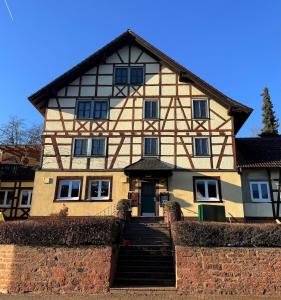 a house with a staircase in front of it at Boardinghouse Zur Rose in Leidersbach +26 photos