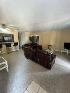 a living room with a brown leather couch in a room at The Moorings Hotel and Marina of Carrabelle in Davis Island