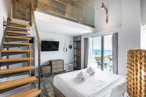 sypialnia z łóżkiem na podwyższeniu i schodami w obiekcie Blue Carpet Luxury Suites w mieście Pefkochori