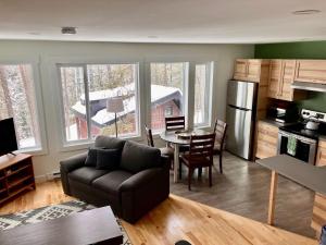 a living room with a couch and a kitchen with a table at Tamarack Suite in Golden