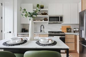 a kitchen with white cabinets and a table with two dishes at Jade Junction in Atlanta +38 photos