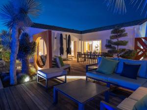 ein Wohnzimmer mit blauen Möbeln und einer Palme in der Unterkunft Villa Harmonie - Luxe, Jaccuzzi et Piscine en Charente-maritime in Saint-Ciers-du-Taillon