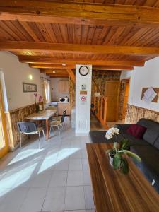 a living room with a couch and a clock on a column at Adler vendégház horgász nyaraló in Gyomaendrőd