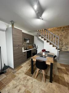 a kitchen with a wooden table and a staircase at Maison de village rénovée in Lédignan