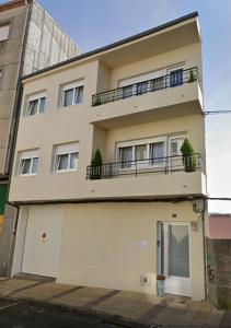 a large white building with a balcony at Gallaecia Dúplex in Arzúa