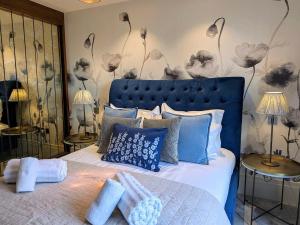 a bedroom with a blue bed with blue pillows at The Old Fire Station Luxury Apartment in York