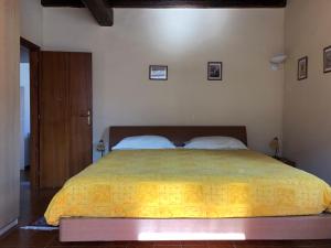 a bedroom with a large bed with a yellow bedspread at La Ca del Bicc in Luino