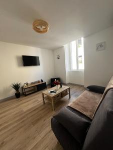 a living room with a couch and a table at Maison de village rénovée in Lédignan +16 photos