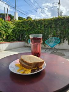 ein Sandwich auf einem Teller mit einem Getränk auf einem Tisch in der Unterkunft Casa Armonia in Playa del Carmen