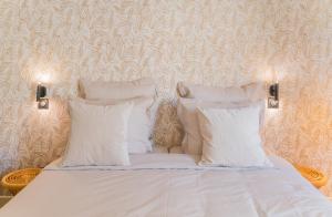 a bed with three pillows on it in a room at Le Gabriel in Strasbourg