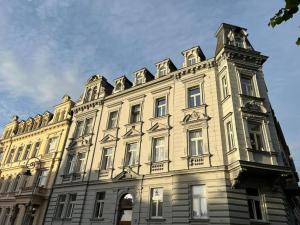 a building with a clock tower on top of it at Residence Polonia - LAST available dates in Karlovy Vary