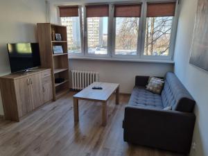 a living room with a couch and a coffee table at Konkrety Lubin in Lubin