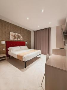 1 dormitorio con 1 cama con cabecero rojo en Domus Chiara al Colosseo, en Roma