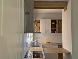 a kitchen with white cabinets and a sink at The Pomegranate Secret in Virós