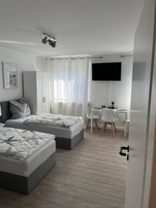 a room with two beds and a table and a television at Schloss Appartement in Paderborn