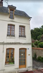 an old white house with brown doors and windows at Location de maison Au fil de l O la Bouille in La Bouille