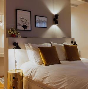1 dormitorio con 1 cama con sábanas blancas y almohadas de oro en Suite no 7, hidden gem center of Amsterdam, en Ámsterdam