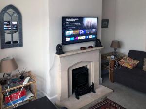 a living room with a fireplace with a flat screen tv above it at Residential 3 bed house Harnham in Salisbury