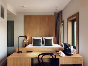 a bedroom with a bed and a wooden desk with a desk at Townhouse Den Haag in The Hague
