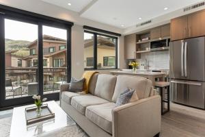 a living room with a couch and a kitchen at Brand New Mountain Modern Westin Amenities Views in Avon