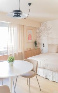 a bedroom with a white bed and a white table at Le Gabriel in Strasbourg