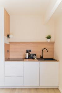 a kitchen with white cabinets and a sink at Le Gabriel in Strasbourg