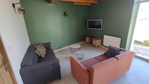 ein Wohnzimmer mit zwei Sofas und einem Fernseher in der Unterkunft La tanière des trois Ogres, à 10min du Futuroscope in Beaumont