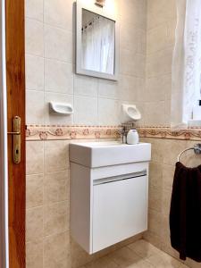 a bathroom with a white sink and a mirror at Mellieha Seaside Apartment in Mellieħa +40 photos