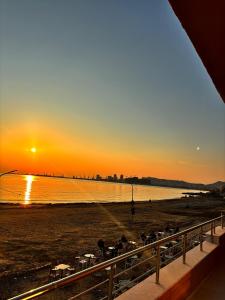 een uitzicht op een strand bij zonsondergang bij Appartamenti Nicola in Durrës