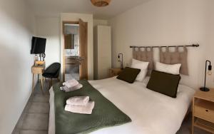 una camera da letto con un letto grande con asciugamani sopra di L’auberge de Montsalier a Le Plan Altre 14 foto