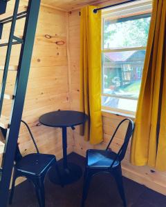 a small table and two chairs in a room with a window at Off Grid Wildwood Bunkies in Bailieboro