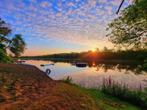 a sunset on a lake with boats in the water at Off Grid Wildwood Bunkies in Bailieboro
