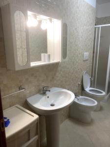 a bathroom with a sink and a toilet and a mirror at Casa Vacanze - Villa Claudia in Leporano Marina +9 photos